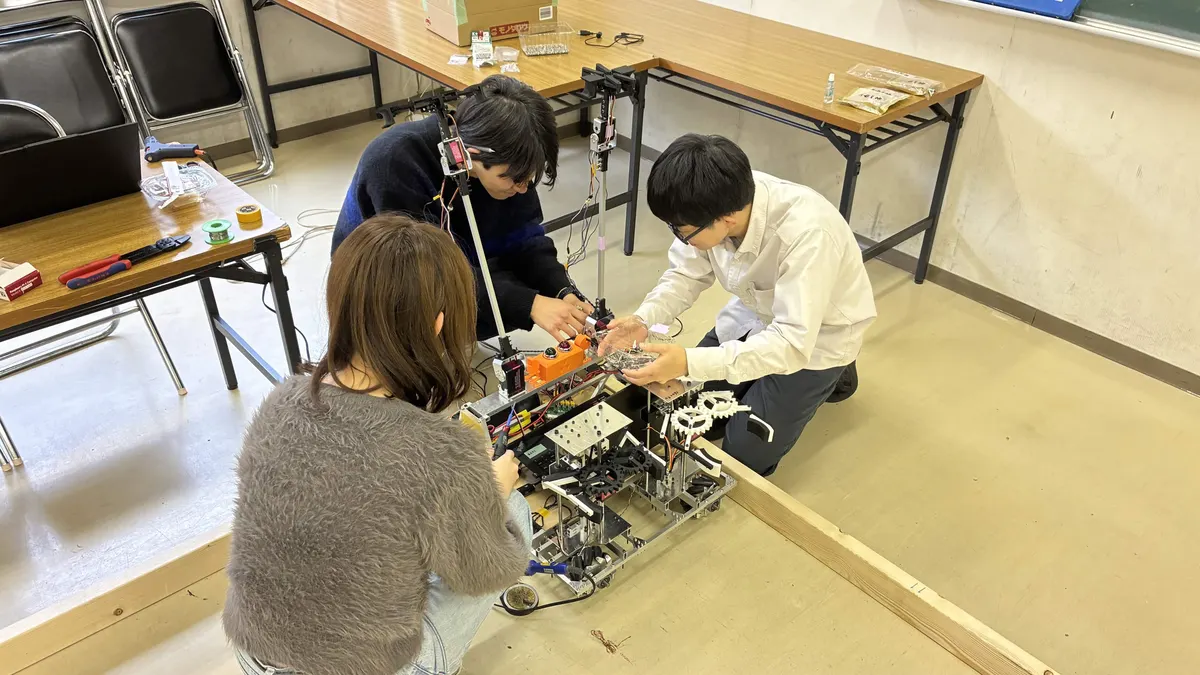 ロボットを囲んで機体の調整をする部員